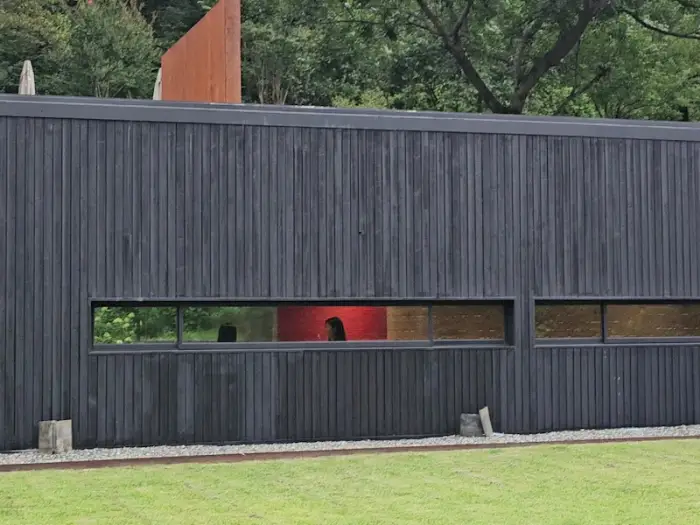 오스갤러리 붉은 목조 건물과 회색 콘크리트 건물의 조화