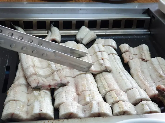 숯불 위에서 익어가는 장어 조각들