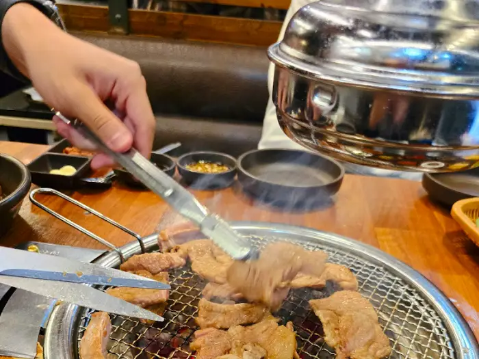 집게로 우대갈비 조각을 집어 올리는 모습