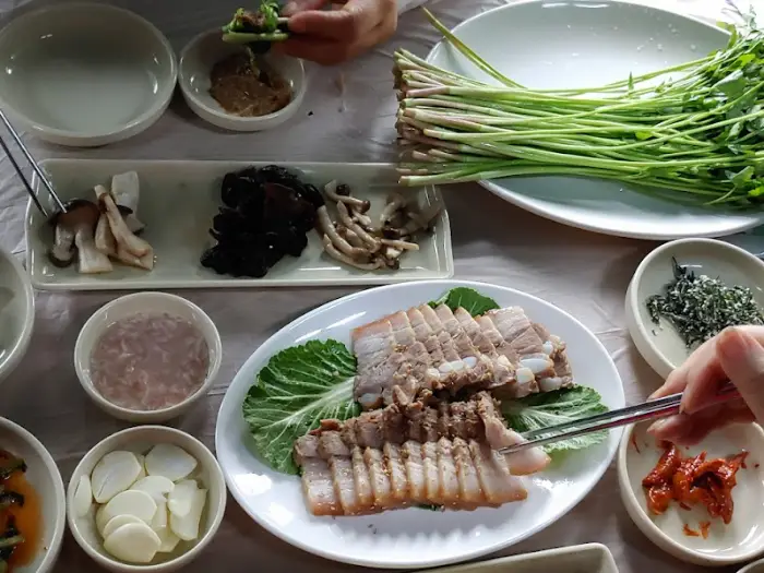 잘 삶아진 수육을 집게로 집는 모습