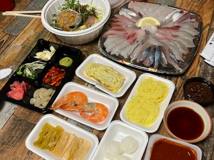 테이블 위에 차려진 푸짐한 회와 물회, 곁들임 찬