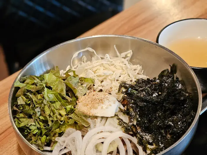 채소가 풍성하게 담긴 비빔막국수