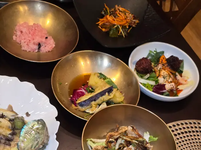 놋그릇에 담긴 밥과 다양한 반찬, 중앙의 튀김 요리