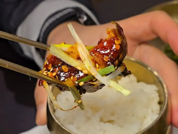 젓가락으로 집어 올린 떡갈비 조각과 밥