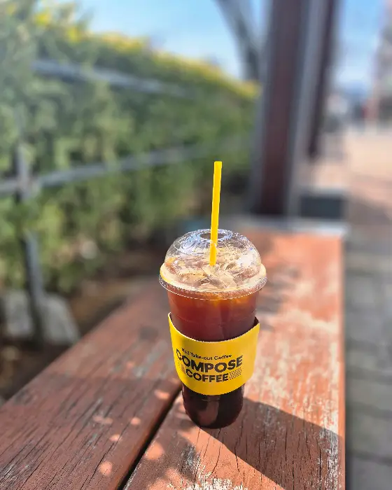 나무 테이블 위에 놓인 아이스 아메리카노 컵