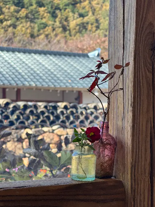 창밖으로 보이는 시골 풍경과 꽃병