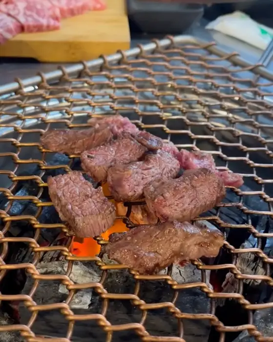 숯불 위에서 구워지는 소고기 여러 점