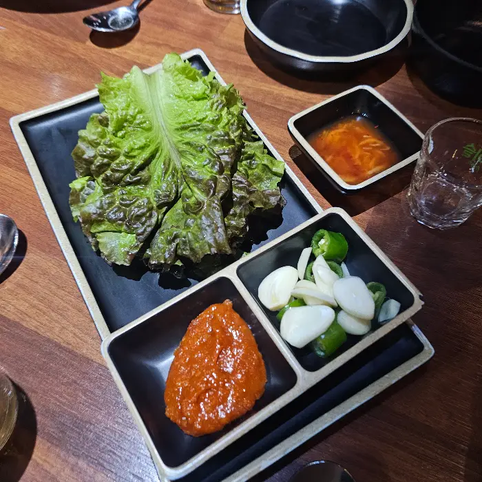 상추, 마늘, 고추, 쌈장이 접시에 담겨 있다.