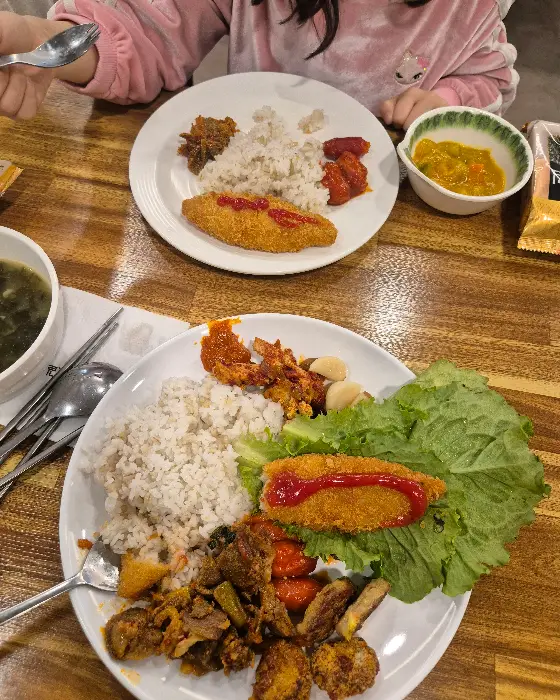 접시에 흰 쌀밥, 생선까스, 김치, 나물 등이 담겨 있는 모습