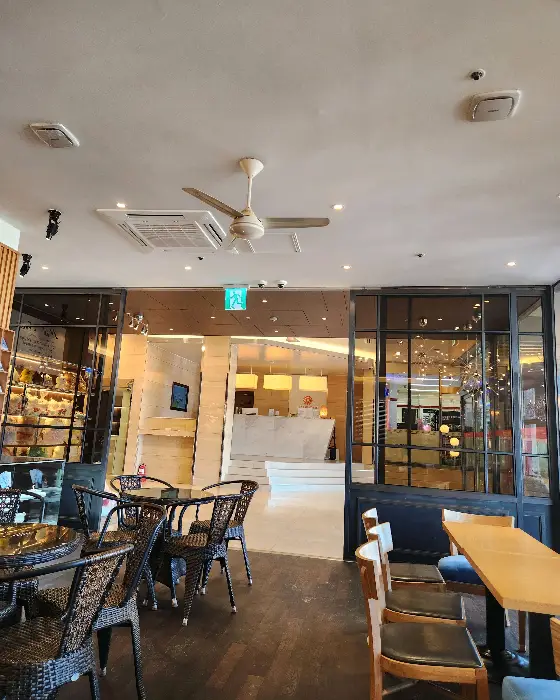 카페 내부의 넓은 테이블과 의자들, 그리고 창문 너머 풍경