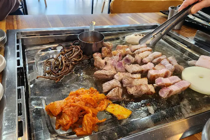 다양한 재료와 함께 쌈을 싸 먹는 모습