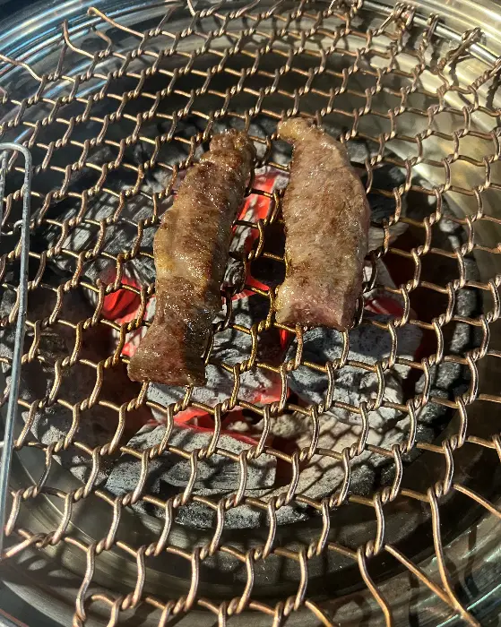 식사 중인 테이블 풍경, 불판 위 고기와 반찬들