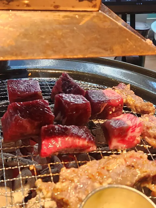 숯불 위에서 익어가는 큐브 모양의 고기 덩어리