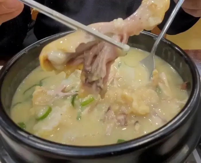 젓가락으로 닭고기를 들어 올리는 모습