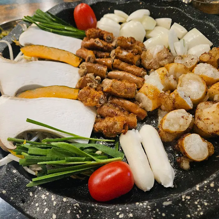 잘 구워진 곱창과 곁들임 채소