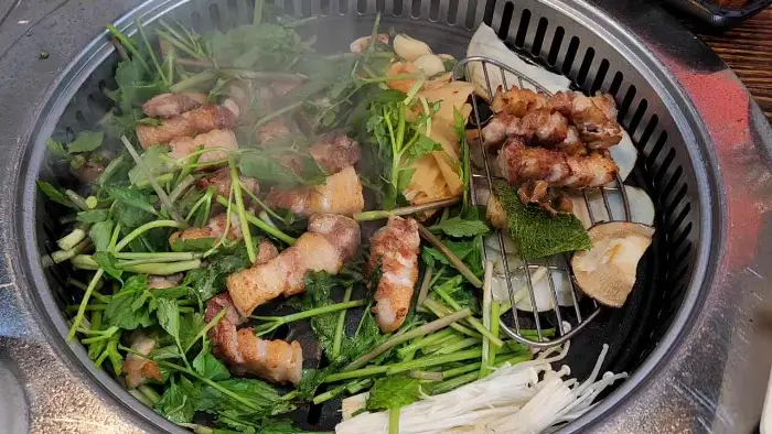 삼겹살과 함께 구워지는 다양한 채소와 버섯