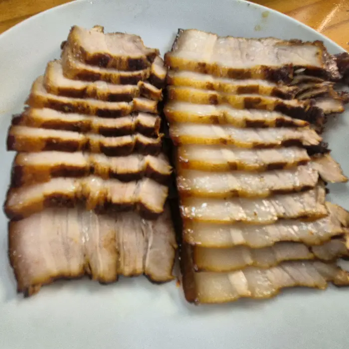 먹기 좋게 썰린 편육 조각들이 접시에 가지런히 놓여 있습니다.