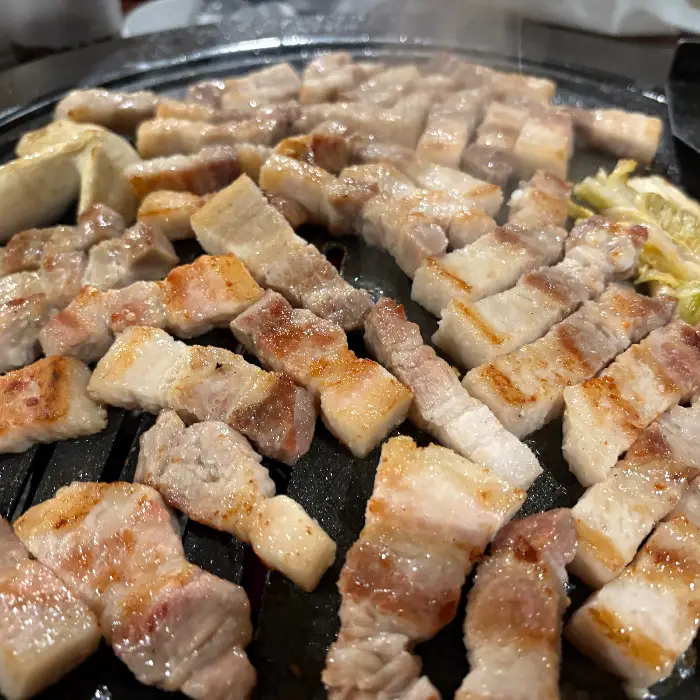 불판 위에서 맛있게 익어가고 있는 삼겹살