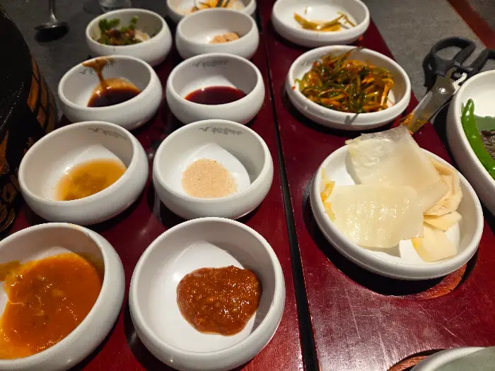 다양한 쌈장과 소스, 그리고 곁들임 찬이 놓여있는 테이블