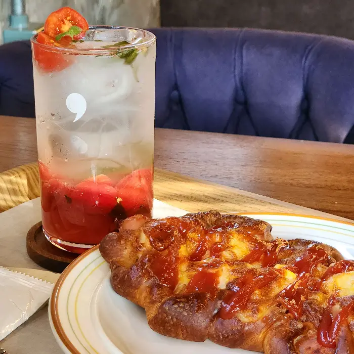 토마토가 곁들여진 시원한 에이드와 먹음직스러운 빵.