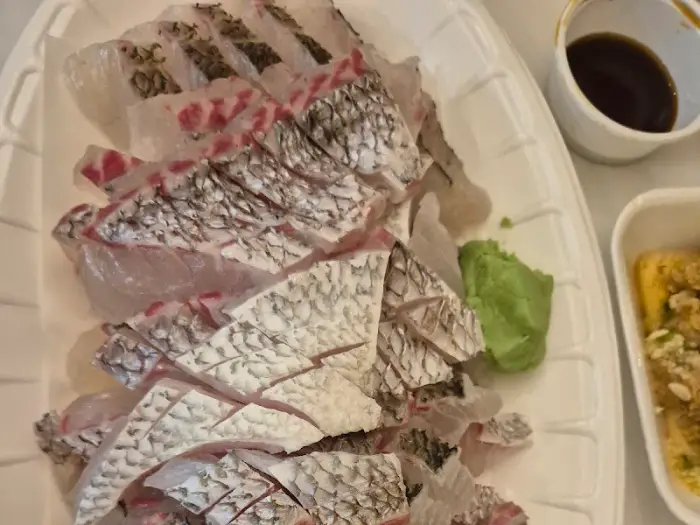 와사비를 올린 초밥 위에 두툼한 참돔 한 점을 얹은 모습