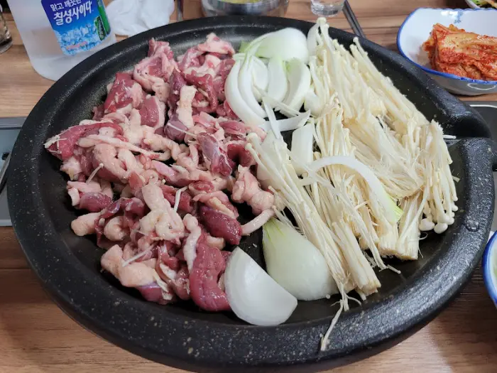 팬에 담긴 익지 않은 오리 양념 불고기 재료와 야채