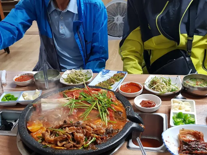 정성스럽게 쌈을 싸서 오리 불고기를 먹는 모습