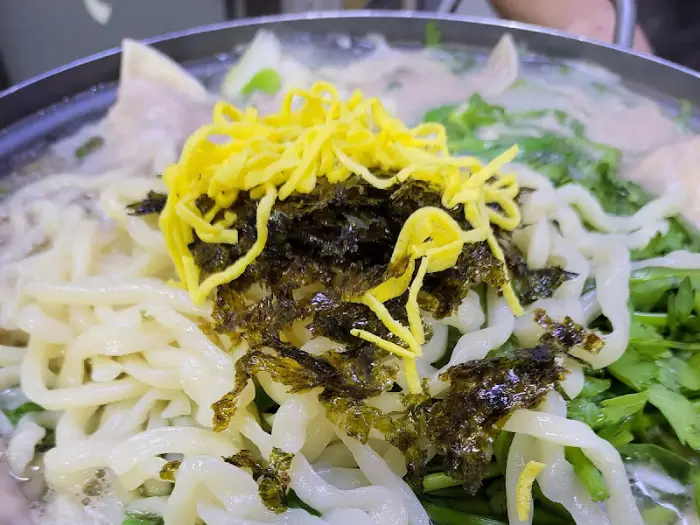 김치와 김가루, 계란 지단 고명이 올라간 푸짐한 칼국수