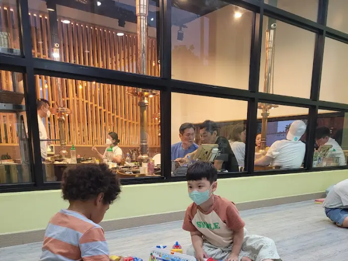 놀고 있는 아이들의 모습과 유리창 너머 보이는 식사 공간의 일부