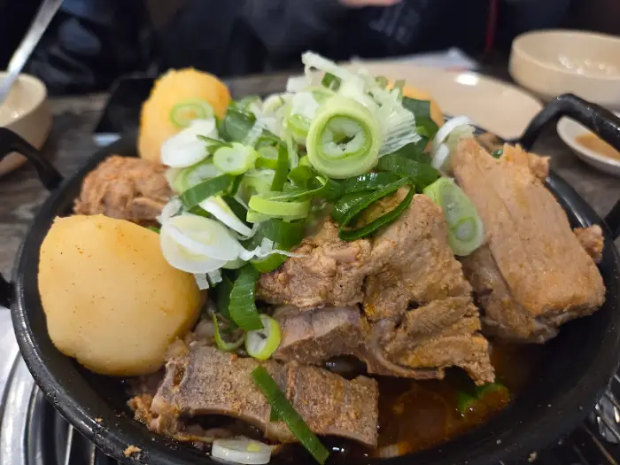 큼직한 뼈와 통감자, 파채가 푸짐하게 담긴 감자탕