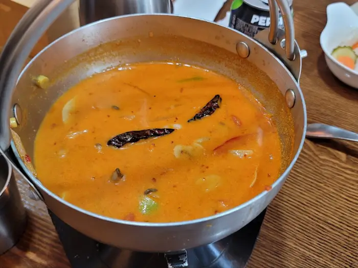 똠얌꿍 - 뚝배기에 담겨 뜨겁게 제공되는 모습, 향긋한 허브가 띄워져 있음