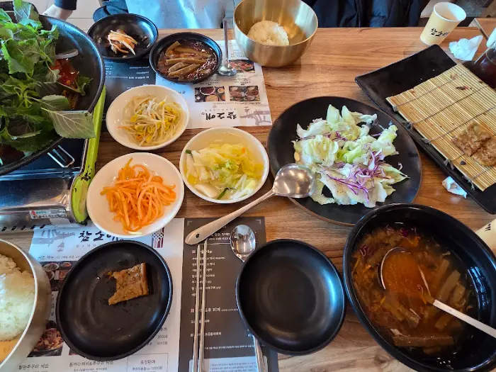 테이블에 차려진 다양한 반찬과 밥, 쭈꾸미 볶음