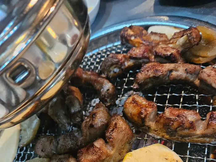 테이블 위 숯불과 함께 세팅된 다양한 반찬들