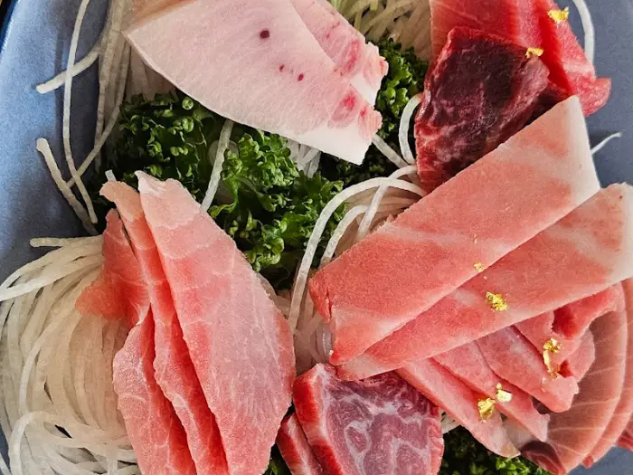 참치회 한 점에 와사비를 얹고 김에 싸먹는 모습