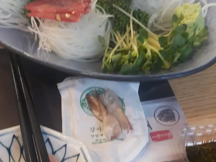 작은 접시에 담긴 새우 한 마리와 곁들임 채소