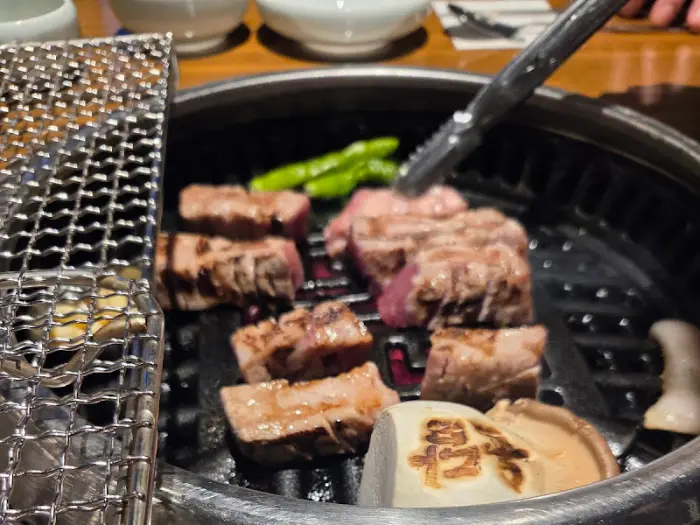 밥 위에 올려진 고기와 밥을 비벼먹는 모습