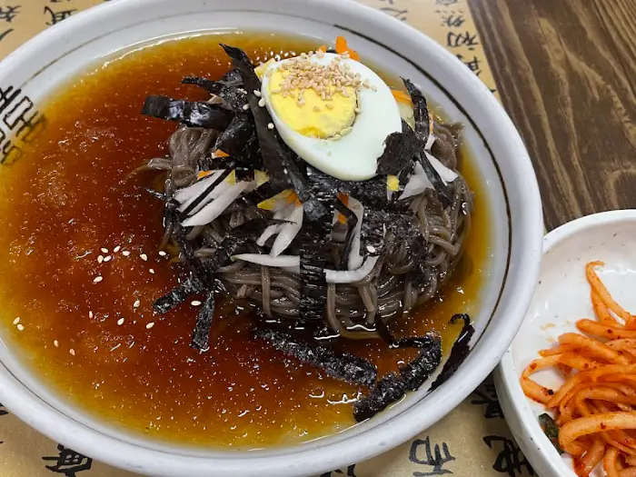 김가루와 양념이 올라간 비빔모밀, 반숙 계란이 토핑되어 있습니다.