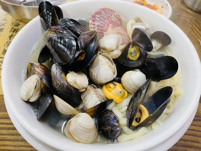 다양한 조개류와 홍합이 빽빽하게 채워진 칼국수.