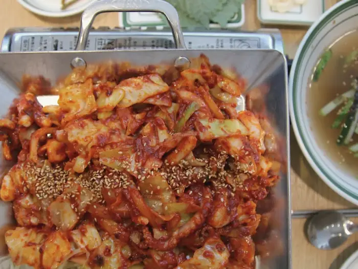 철판에 조리된 낙지 요리와 곁들여 나온 국물.