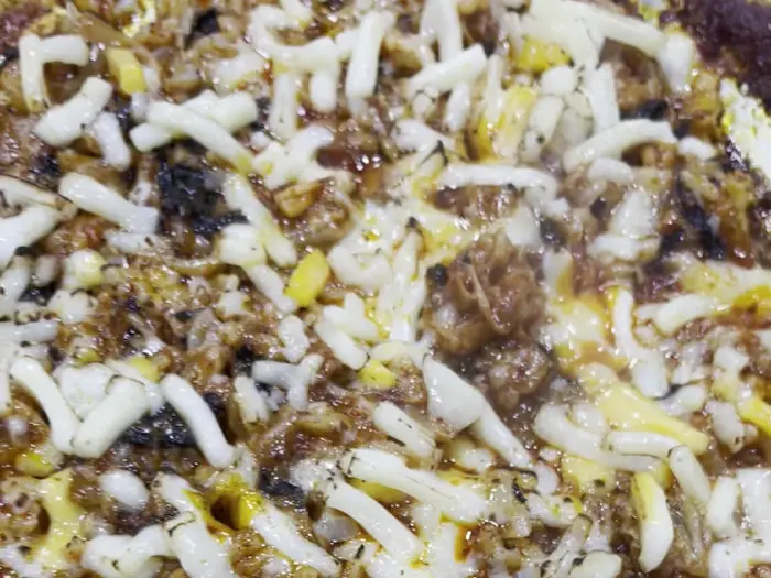 치즈가 듬뿍 올라간 볶음 요리의 클로즈업.