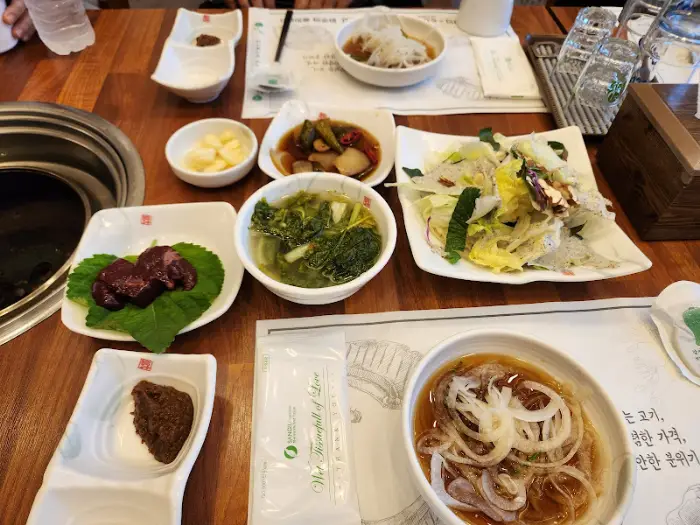 테이블 위에 놓인 다양한 밑반찬과 샐러드