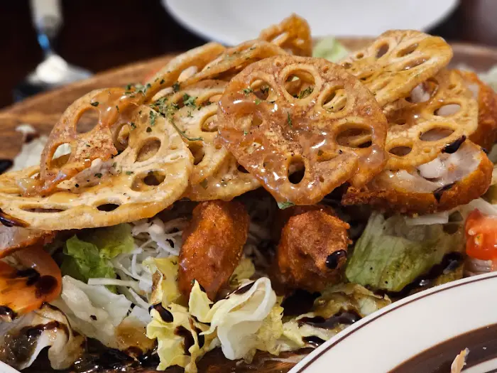 샐러드 위에 튀긴 연근, 닭고기, 채소가 풍성하게 올라간 모습