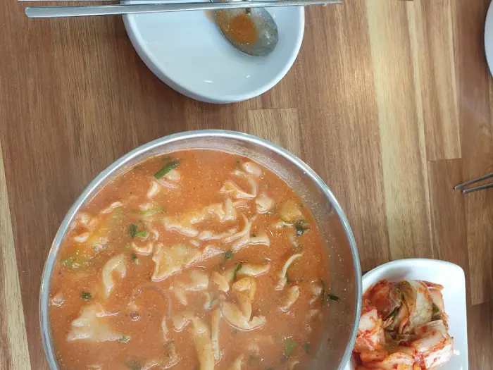 테이블에 놓인 어탕과 김치, 젓가락, 숟가락 모습