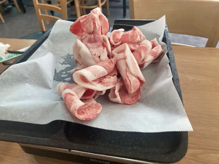 삼겹살 한 점을 집어 상추에 싸는 모습