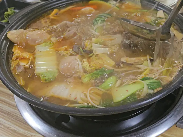 끓고 있는 전골에 야채와 당면이 가득한 모습