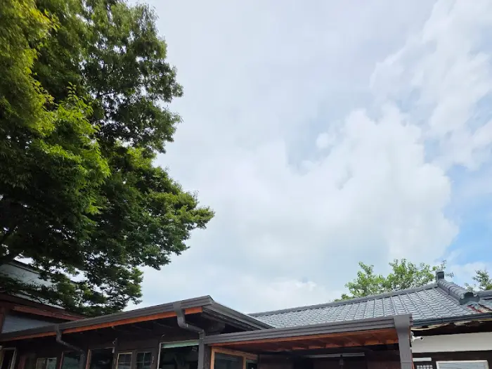 기와 지붕과 나무 처마가 조화롭게 어우러진 토가의 외관. 한국 전통 가옥의 아름다움을 보여준다.