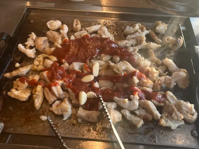 곱창 위에 특제 양념 소스를 붓는 장면