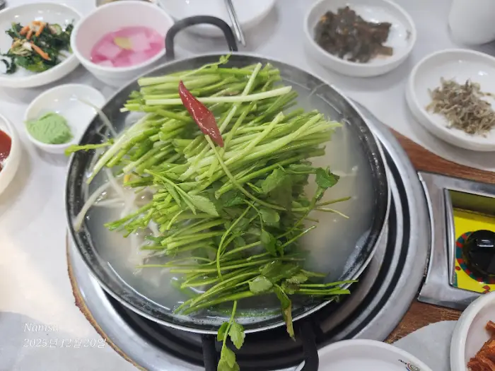 미나리와 콩나물이 듬뿍 올려진 탕 냄비