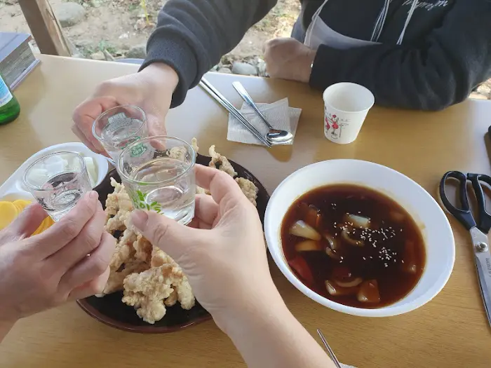 술잔을 부딪히는 모습과 탕수육, 짬뽕 국물