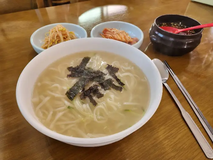 뽀얀 칼국수 국물과 김가루, 썰은 파가 올라간 모습
